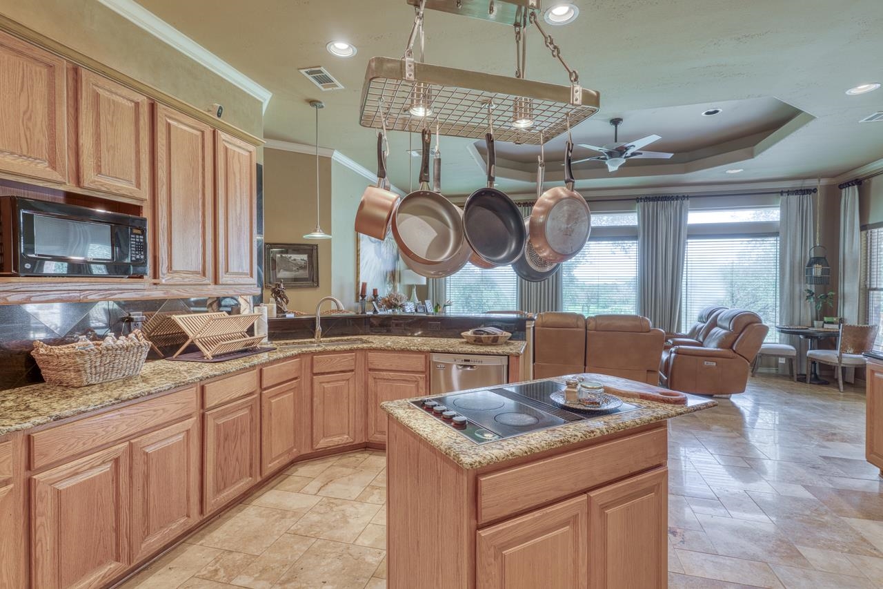 1612 Swear Injun Horseshoe Bay, TX 78657 - Photo 11 of 30 a kitchen with granite countertop a sink a stove and cabinets