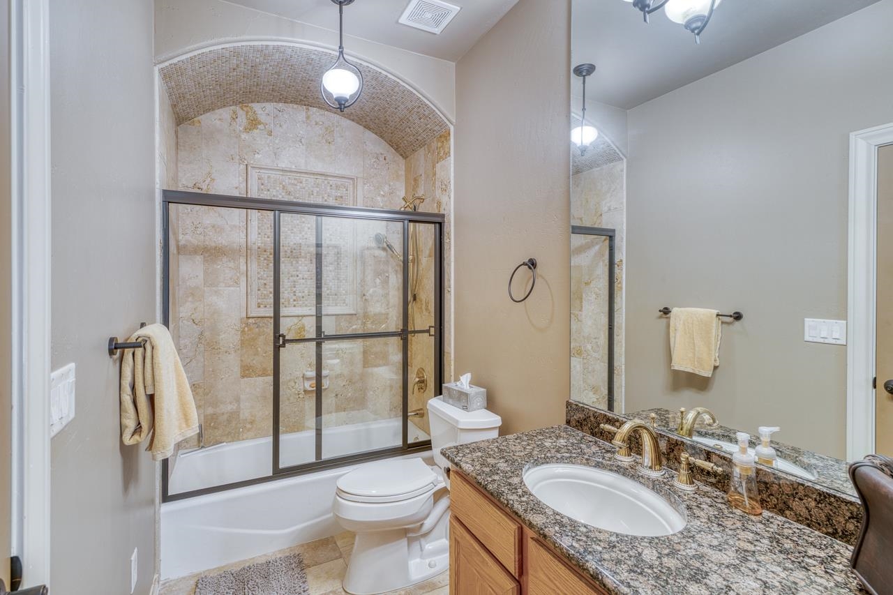 1612 Swear Injun Horseshoe Bay, TX 78657 - Photo 19 of 30 a bathroom with a granite countertop sink toilet and shower