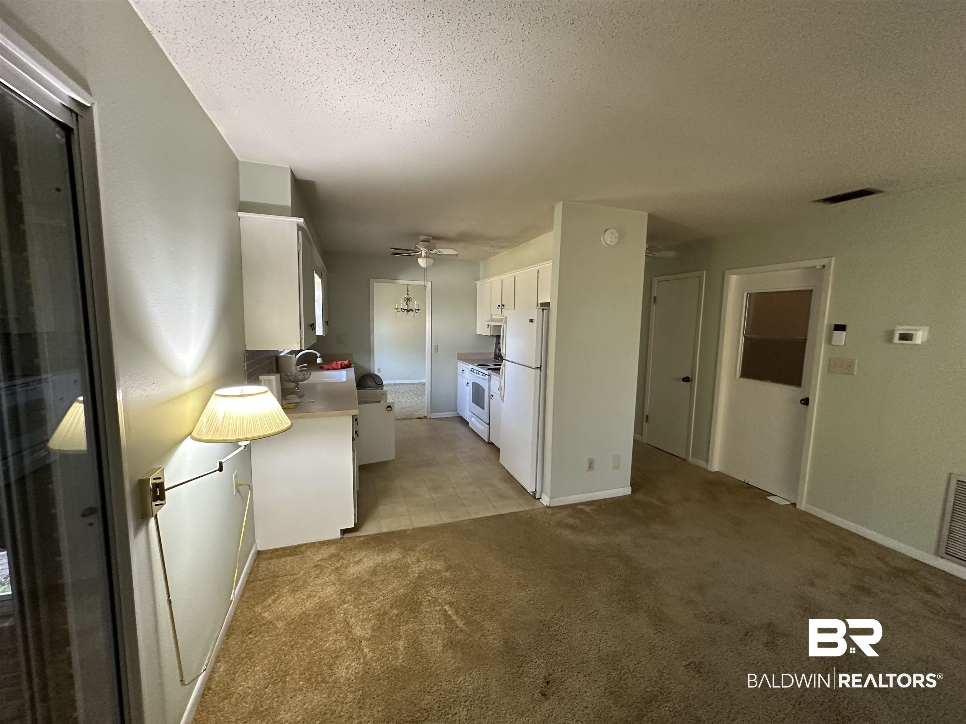 1 Yupon Circle Foley, AL 36535 - Photo 24 of 30 Kitchen featuring white cabinets, white appliances, light countertops, a textured ceiling, and light carpet