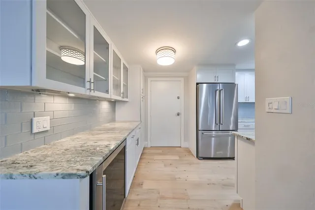 a kitchen with stainless steel appliances granite countertop a refrigerator a oven and a sink with granite countertops