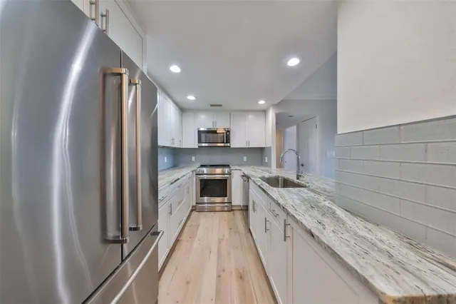 a large kitchen with a large window and stainless steel appliances