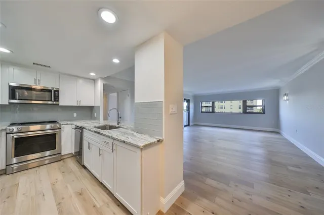 a kitchen with granite countertop a stove top oven and sink