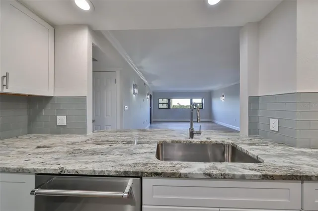 a kitchen with granite countertop a sink and a stove