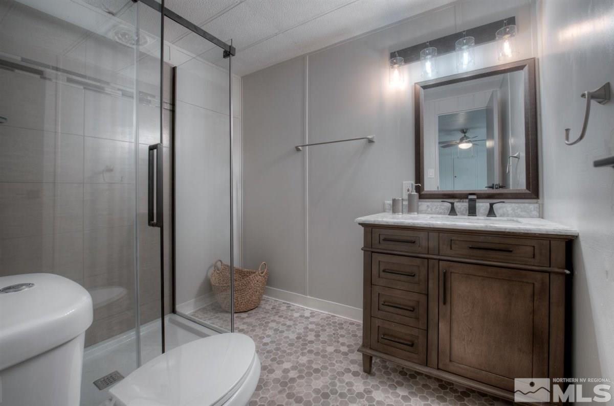 180 Chlorite Court Reno, NV 89521 - Photo 11 of 33 a bathroom with a granite countertop sink toilet and mirror