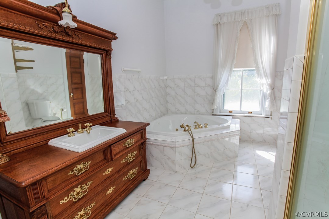 4016 Hermitage Road Richmond, VA 23227 - Photo 16 of 24 a bathroom with a tub sink and mirror