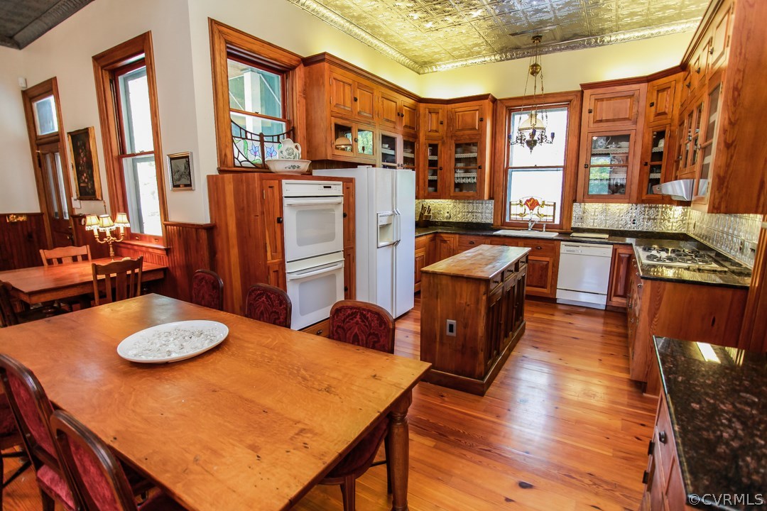 4016 Hermitage Road Richmond, VA 23227 - Photo 8 of 24 a kitchen with stainless steel appliances granite countertop a stove a refrigerator a oven a dining table and chairs with wooden floor