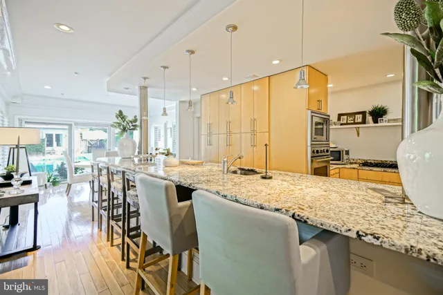 a kitchen with white cabinets appliances a sink and a window