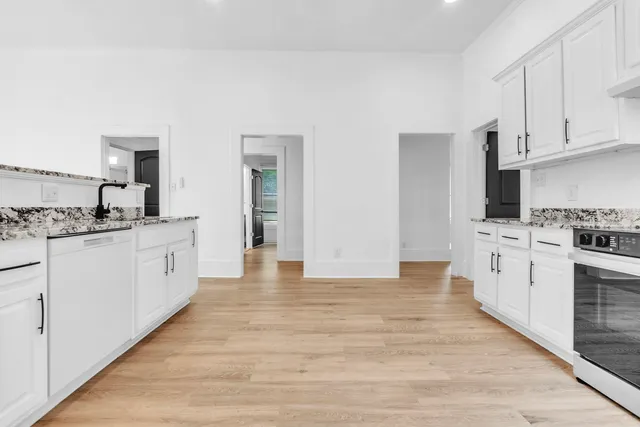 a kitchen with cabinets oven and a sink
