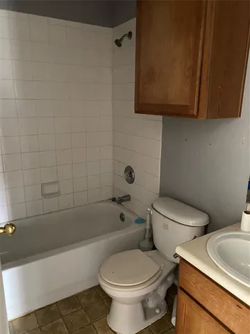 a white toilet sitting next to a bath tub