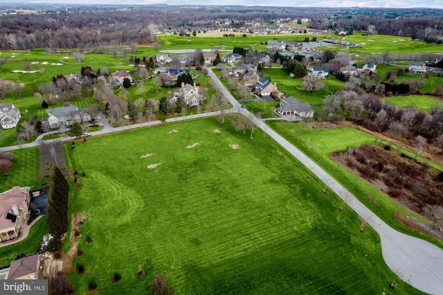 a view of a green field with wooden fence