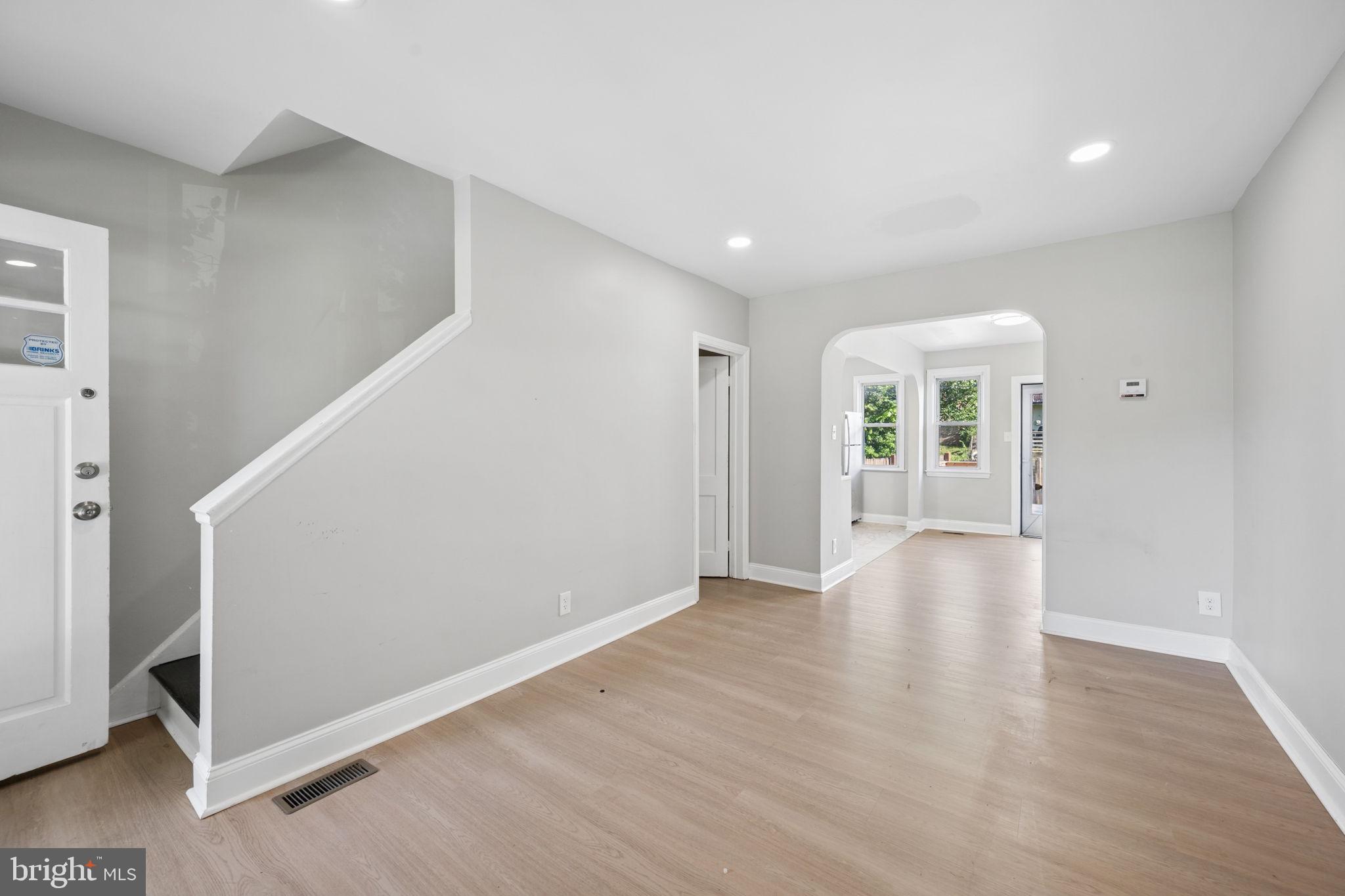 3548 Benzinger Road Baltimore, MD 21229 - Photo 4 of 40 a view of an empty room with wooden floor and a window