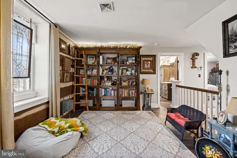 a bedroom with a bed and wooden floor