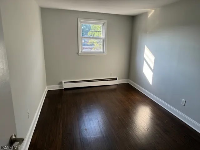 an empty room with wooden floor and closet