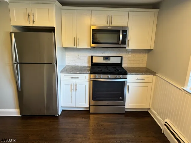 a view of a kitchen with wooden floor and a window