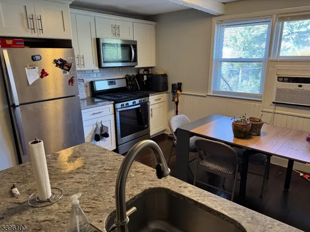 a living room with furniture a flat screen tv and a window
