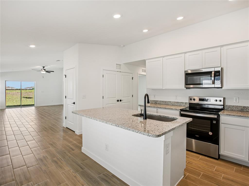Undisclosed Address Lakeland, FL 33809 - Photo 4 of 7 a kitchen with stainless steel appliances granite countertop a sink a stove top oven a counter space and cabinets