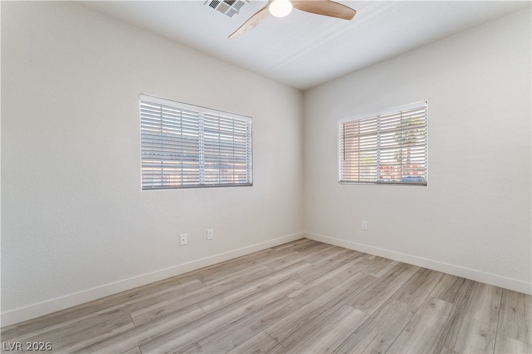 4730 East Craig Road, Unit 1058 Las Vegas, NV 89115 - Photo 23 of 30 A quiet bedroom featuring elegant wood-look flooring and a modern ceiling fan for year-round comfort.