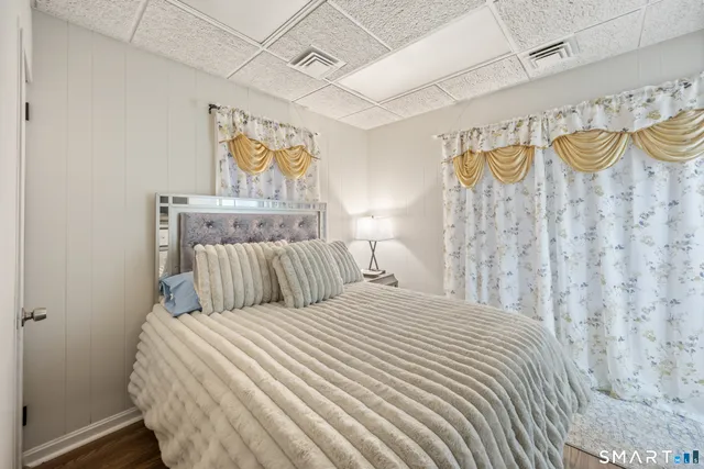 a bedroom with a bed and painting on the wall