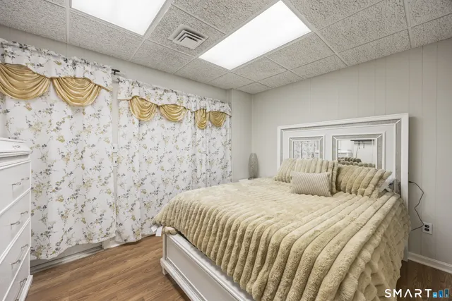 a bedroom with a bed and painting on the wall