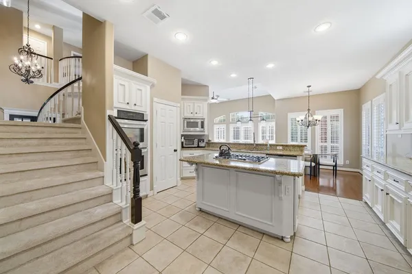 a kitchen with stainless steel appliances kitchen island granite countertop a stove a sink and a refrigerator