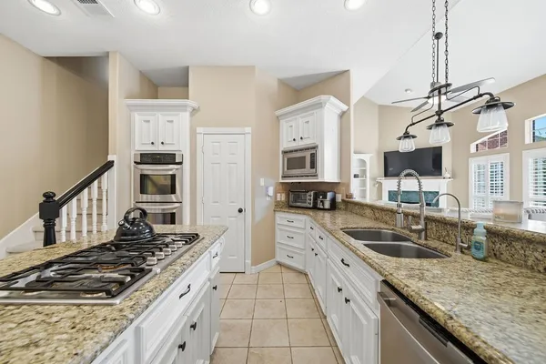 a kitchen with stainless steel appliances granite countertop a sink stove and cabinets