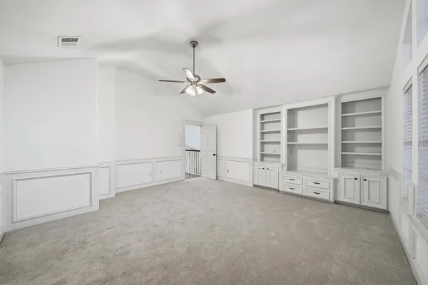 an empty room with windows and cabinet