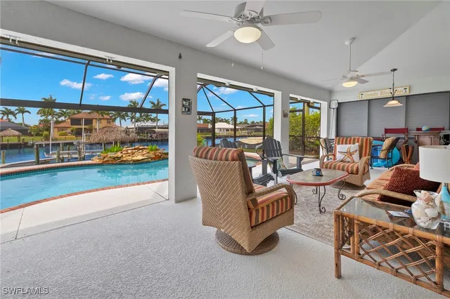 a living room with patio furniture and a floor to ceiling window