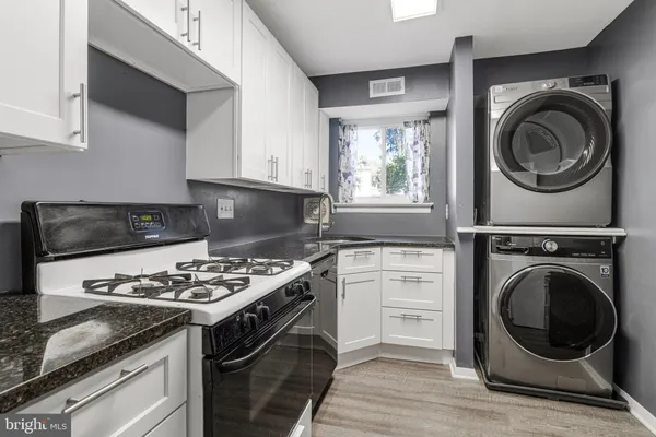 a kitchen with kitchen island a stove a sink and a microwave