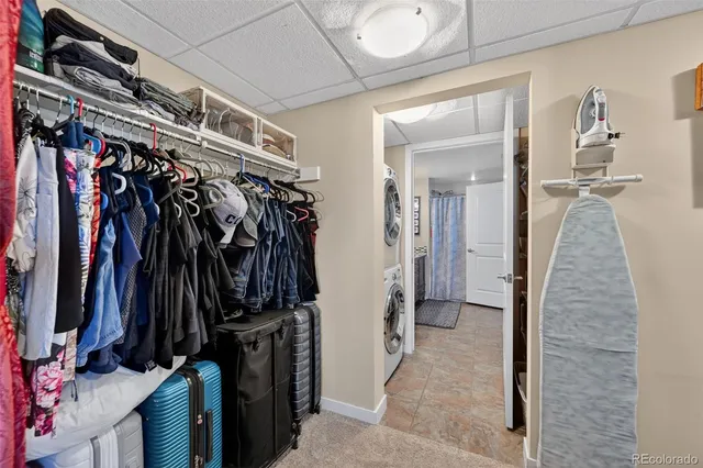 a view of walk in closet with clothes and shoes