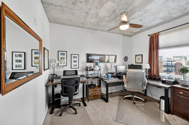 a view of a livingroom with workspace and a window
