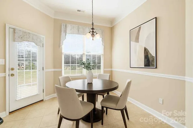 a dining room with furniture a chandelier and wooden floor