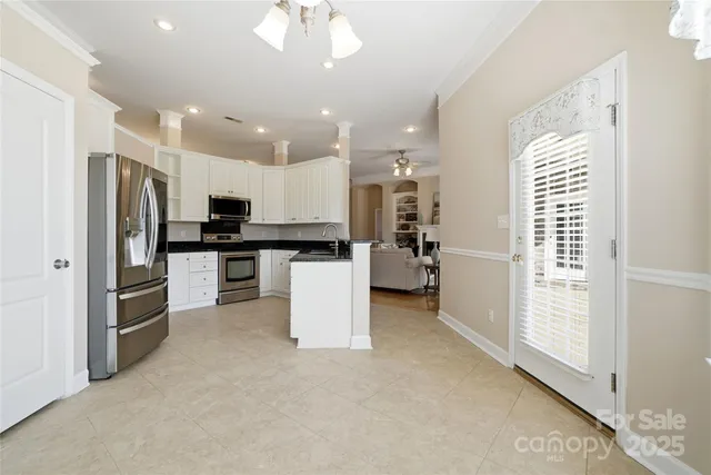 a kitchen with stainless steel appliances kitchen island granite countertop a refrigerator and a stove top oven