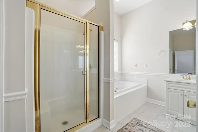 a bathroom with a tub shower sink and mirror