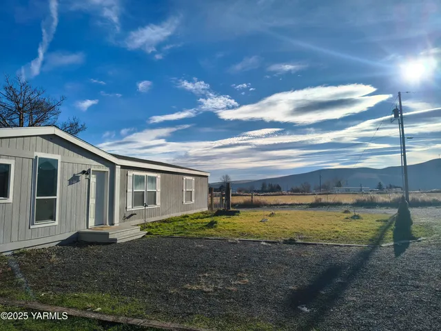 a view of a house with backyard and sitting area