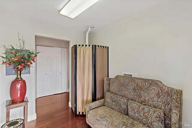 a living room with furniture flowerpot and wooden floor