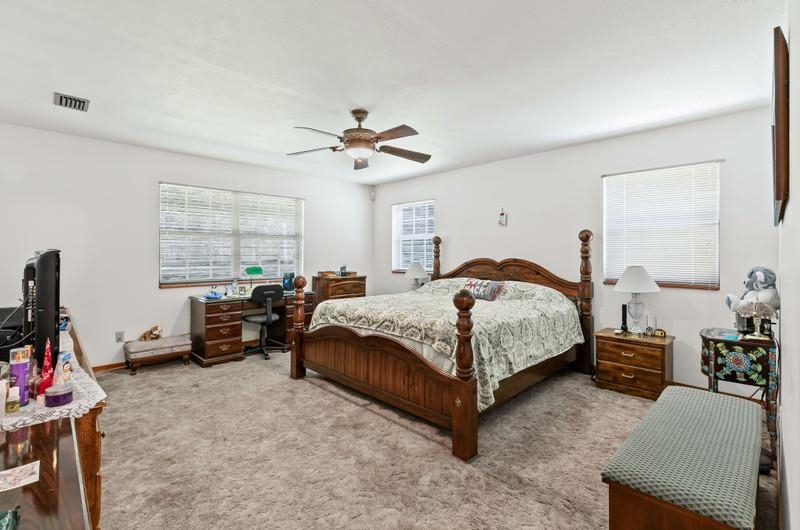 2650 Cabbage Hammock Road St. Augustine, FL 32092 - Photo 30 of 91 a spacious bedroom with a bed a couch and a chandelier