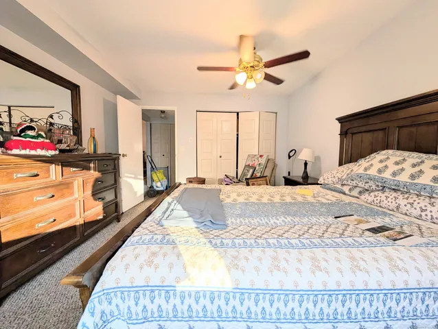 a bedroom with a bed and a flat tv screen on dresser