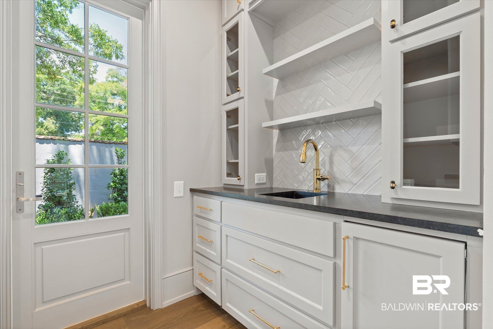 3 Canterbury Park Mobile, AL 36608 - Photo 9 of 43 Indoor wet bar featuring decorative backsplash and wood finished floors