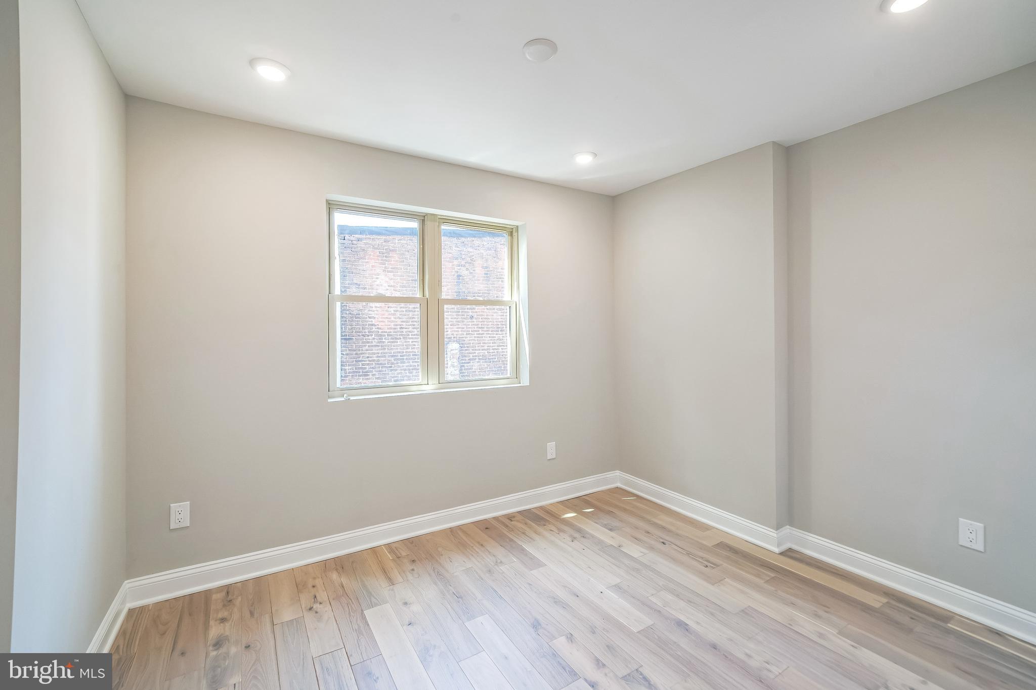 1702 South 22nd Street, Unit 2 Philadelphia, PA 19145 - Photo 15 of 19 an empty room with wooden floor and windows