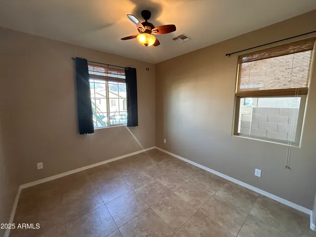 an empty room with windows and fan