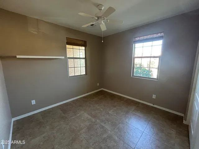 an empty room with a window and a fan