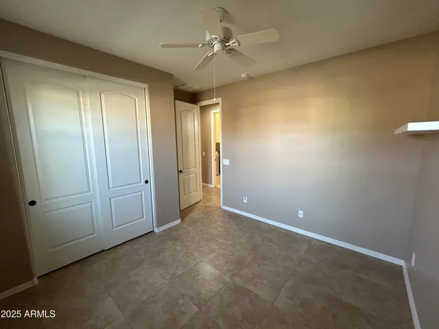 an empty room with a ceiling fan and a window
