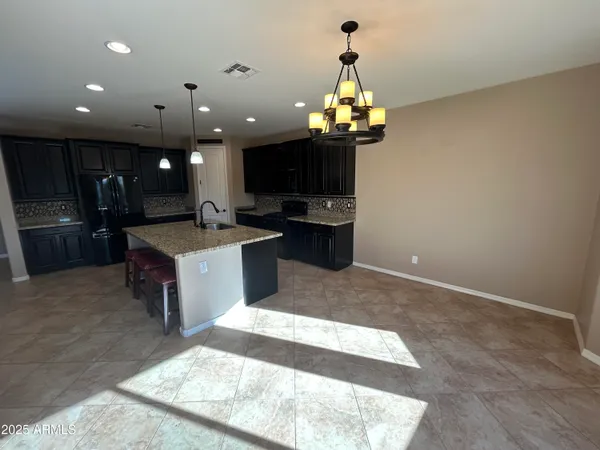a large kitchen with kitchen island a sink stainless steel appliances and cabinets