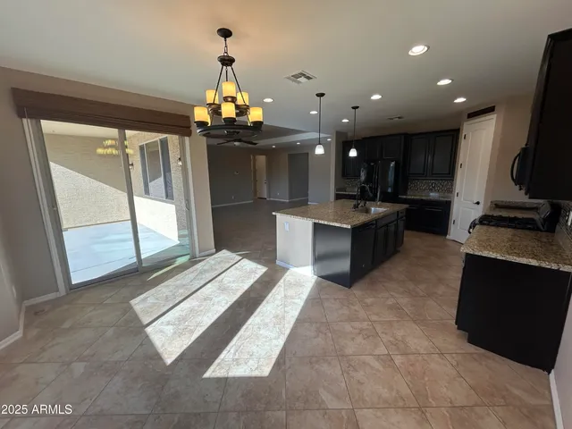 a kitchen with stainless steel appliances kitchen island granite countertop a refrigerator and a stove top oven