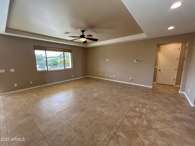 en empty room with windows and ceiling fan