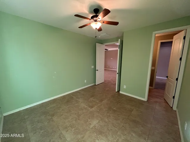 a view of a room with a ceiling fan and closet