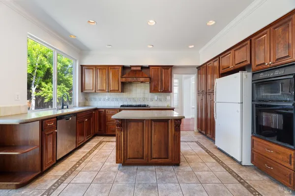 a kitchen with stainless steel appliances granite countertop a stove a sink dishwasher and a refrigerator