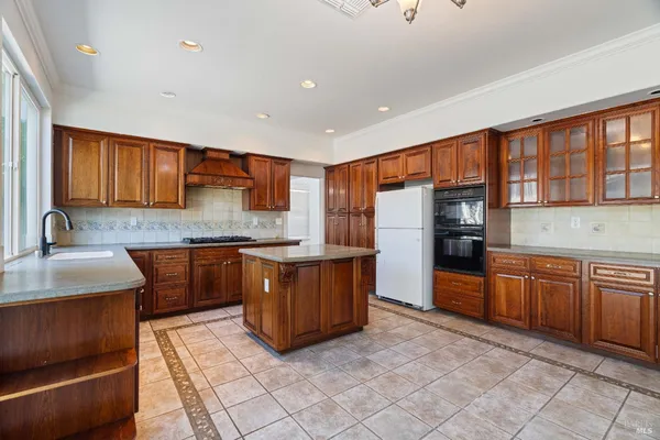 a large kitchen with stainless steel appliances granite countertop a stove a sink and a microwave