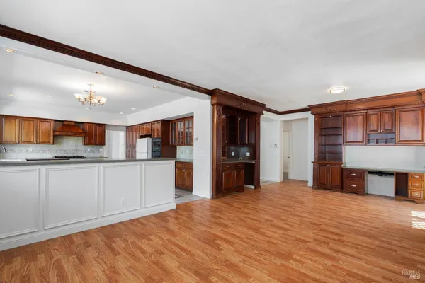 a kitchen with stainless steel appliances kitchen island granite countertop a refrigerator and cabinets