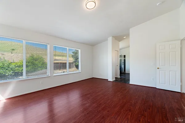 a view of empty room with wooden floor